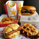 Table displaying Hardee's fries, fountain drink, tenders, and three new chicken sandwiches